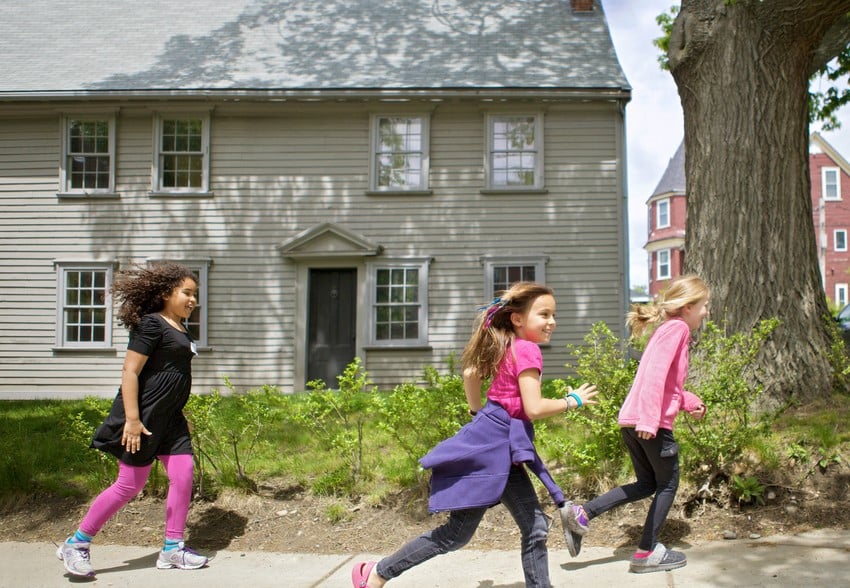 Children running on the sidewalk in front of 17th century Pierce House