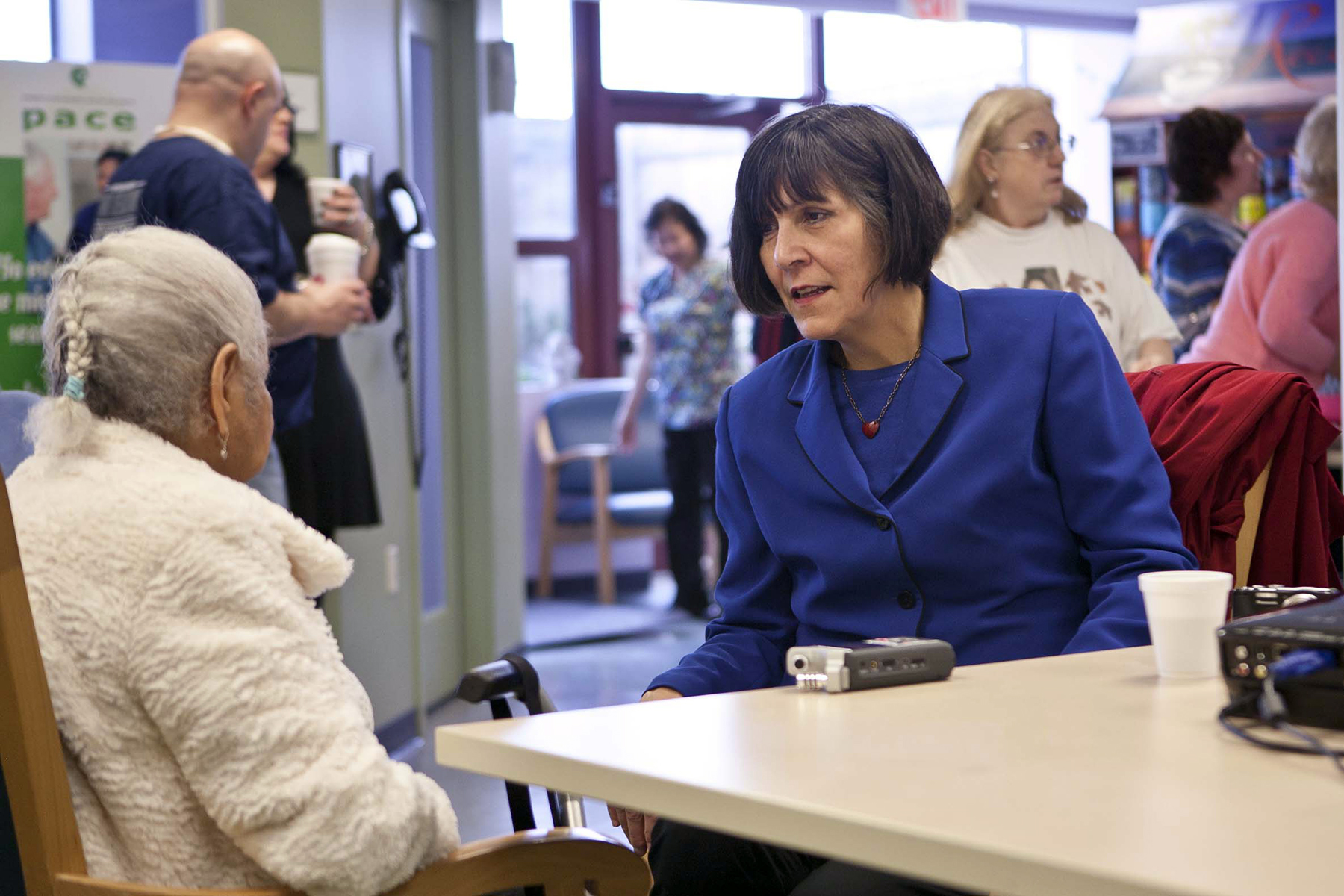 Woman in blue dress interviewing another woman for an oral history project for Rhode Island Latino Arts